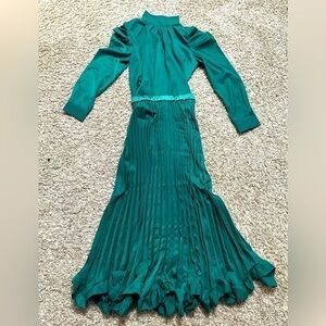 PLEATED SKIRT WITH RUFFLES AND A HIGH NECK BLOUSE .